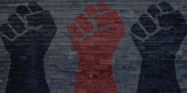 three fists painted on a brick wall