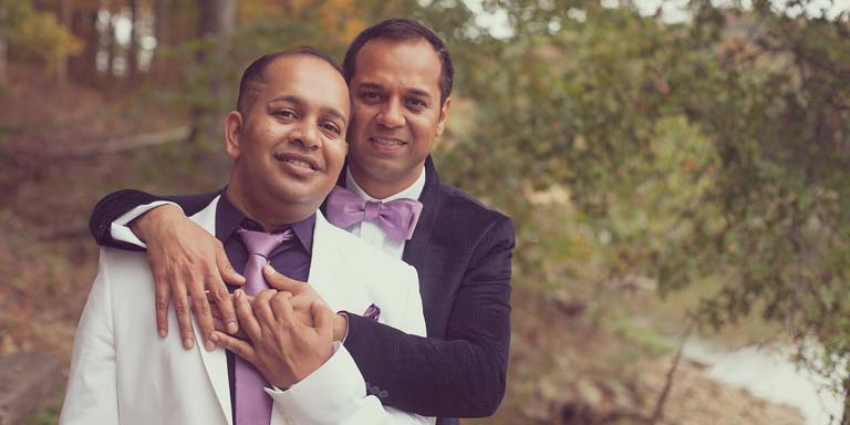 Two men embracing in suits with purple ties